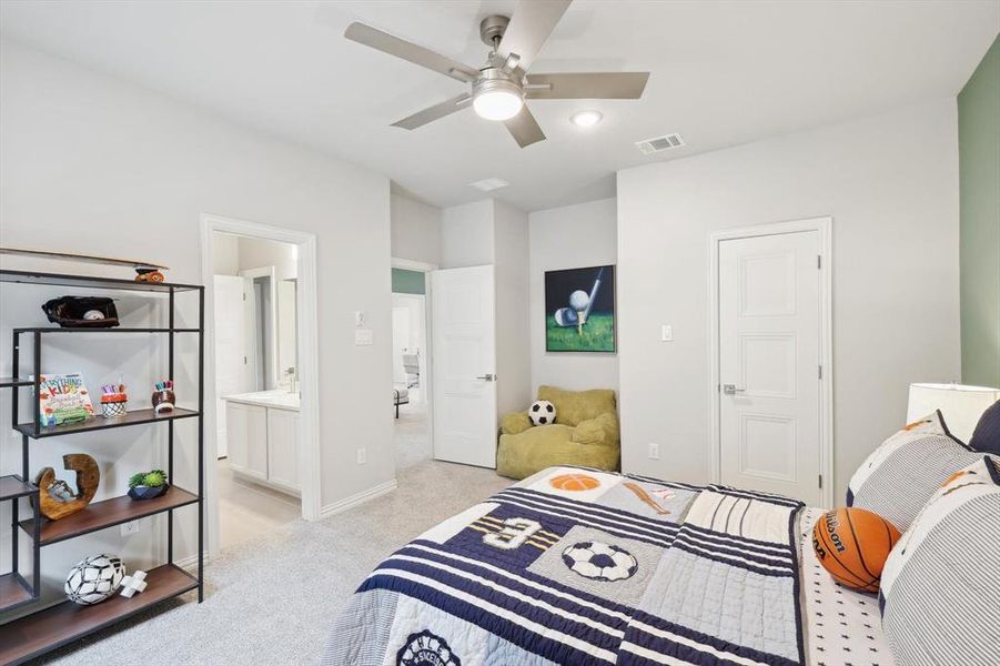 Bedroom with light carpet, ceiling fan, and connected bathroom
