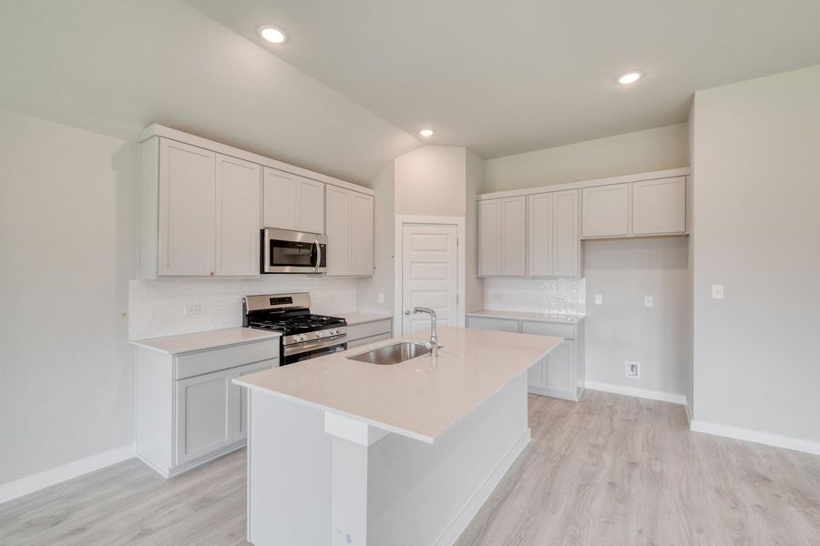 A well-appointed kitchen features stainless steel appliances, pristine white cabinetry, and recessed lighting. A well-appointed kitchen features stainless steel appliances, pristine white cabinetry, and recessed lighting.