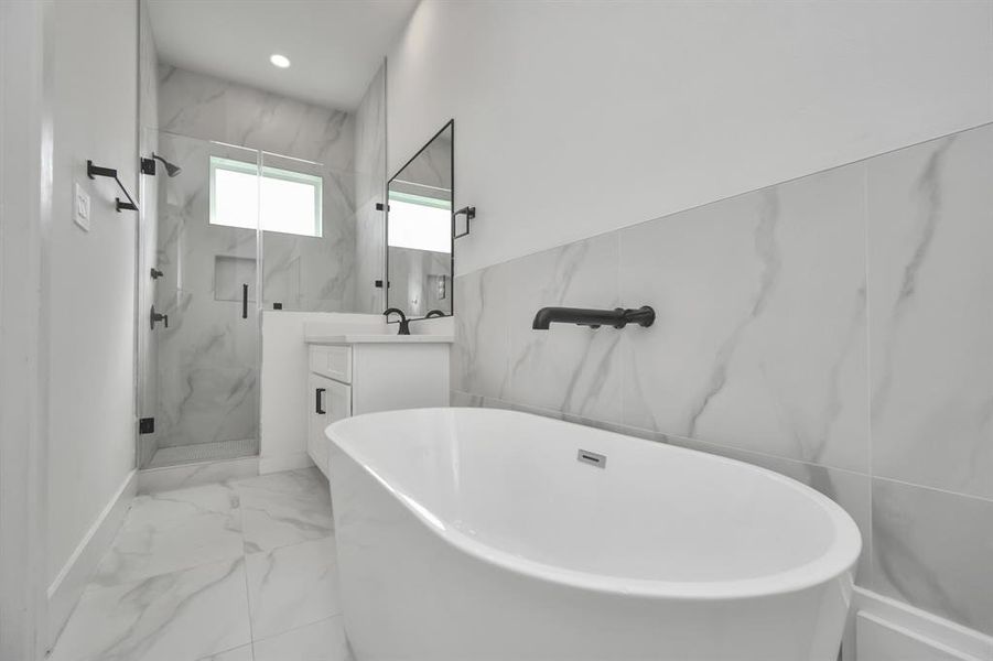 Another view of the luxury that is the primary bath, highlighted the two beautifully appointed vanity areas, spacious soaking tub and walk in closet