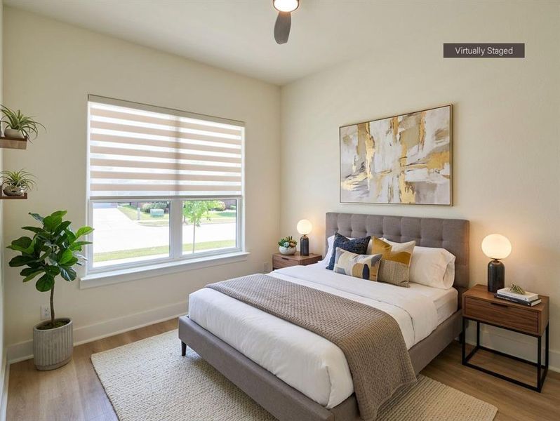 Bright room featuring a large window with horizontal blinds, wood-finish flooring, and light-toned walls