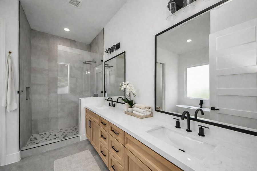 Spa-like primary bathroom retreat featuring a freestanding soaking tub, walk-in shower, and clean modern finishes.