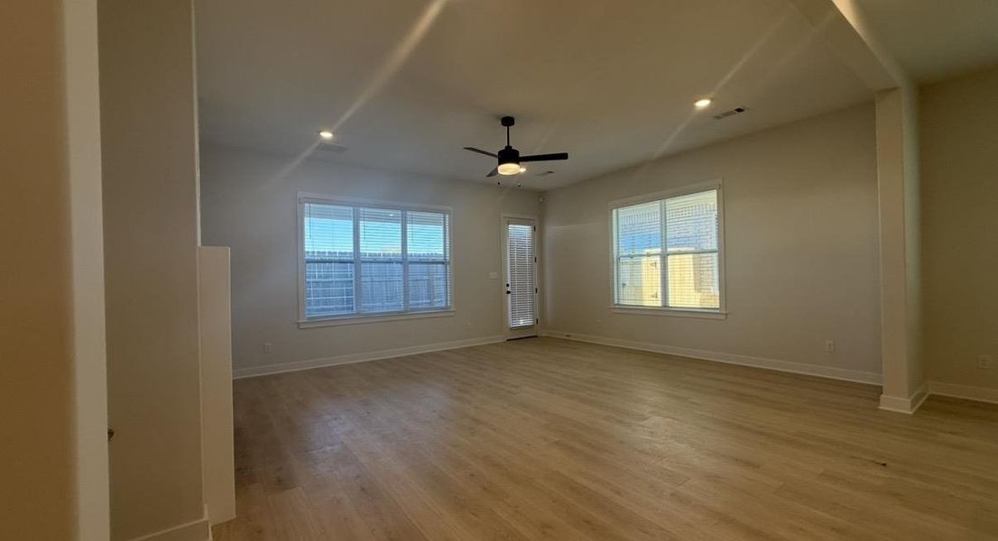 Unfurnished room featuring healthy amount of natural light, ceiling fan, light wood-type flooring, and recessed lighting