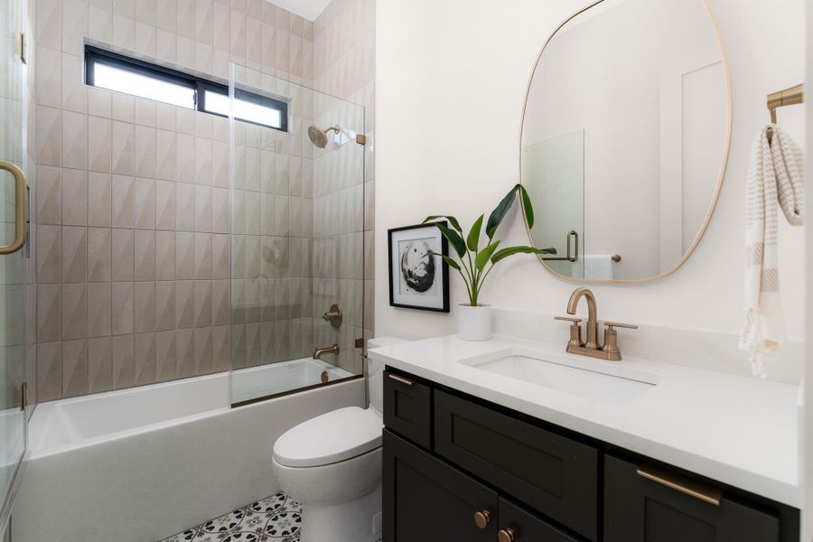 A well-appointed bathroom with patterned floor tiles and a sleek vanity.