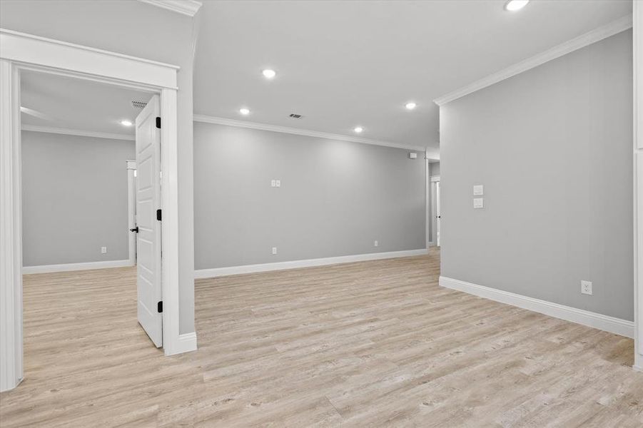 Unfurnished room featuring ornamental molding and light hardwood / wood-style flooring