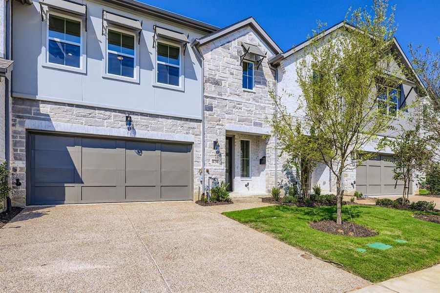 View of front facade featuring stone siding, a garage, and concrete driveway View of front facade featuring stone siding, a garage, and concrete driveway