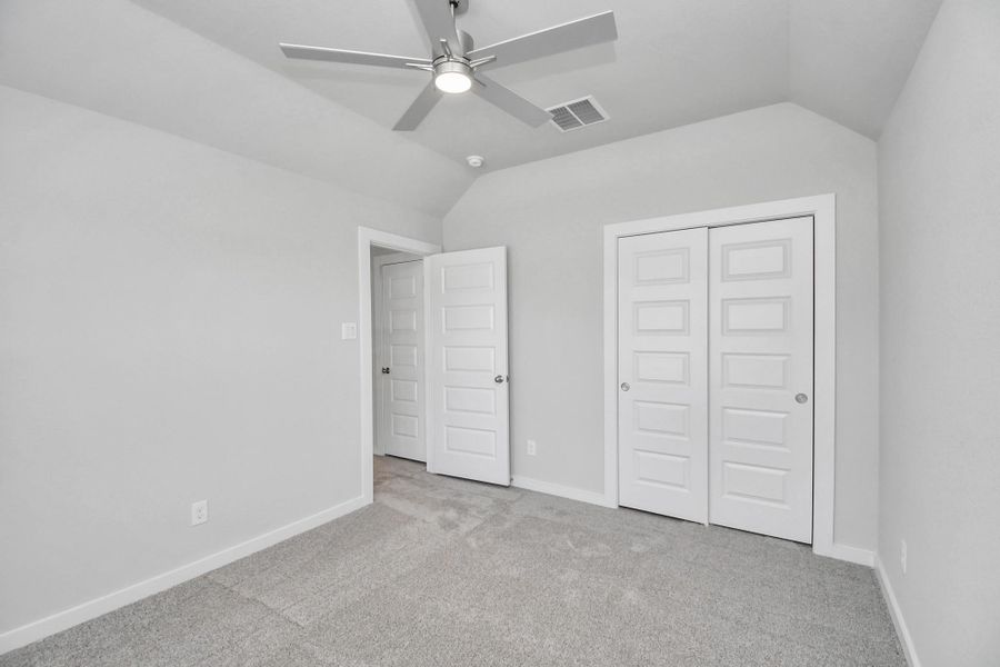 Secondary bedroom features plush carpeting, large windows that let in plenty of natural light, bright paint, and spacious closets.