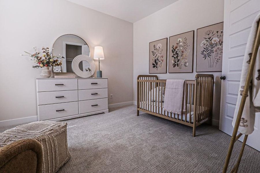 Bedroom with a crib and light colored carpet