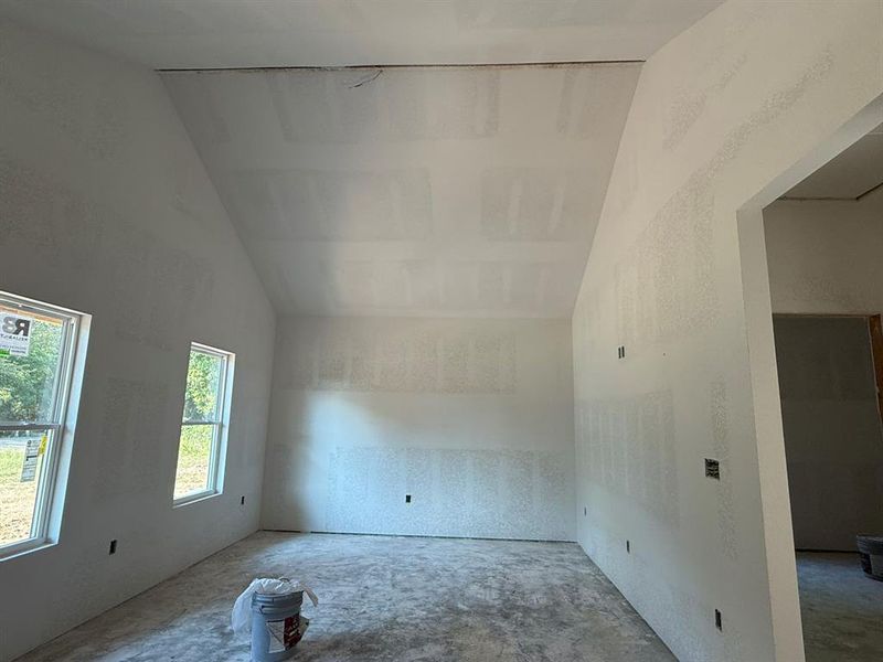 Empty room featuring vaulted ceiling