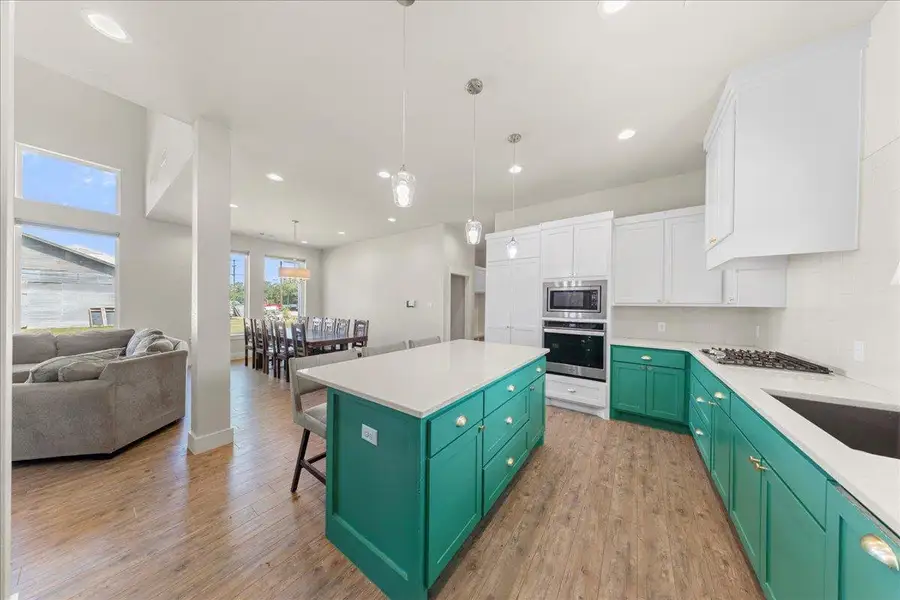 Kitchen featuring green cabinetry, white cabinets, stainless steel appliances, light wood-style flooring, and recessed lighting Kitchen featuring green cabinetry, white cabinets, stainless steel appliances, light wood-style flooring, and recessed lighting