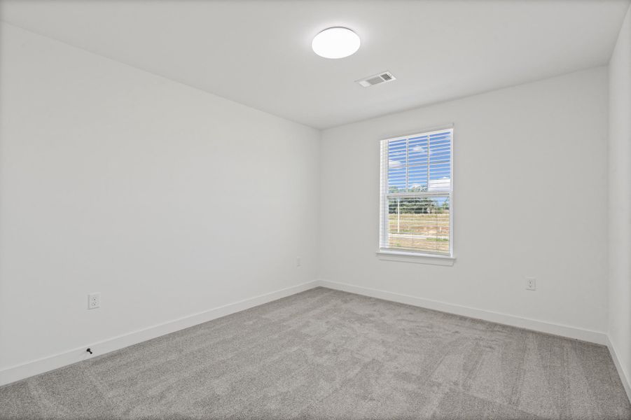 Neutral color palette with light gray carpeting, crisp white walls, and a recessed window featuring blinds