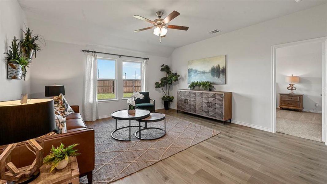 Sitting room with ceiling fan, wood finished floors, and lofted ceiling