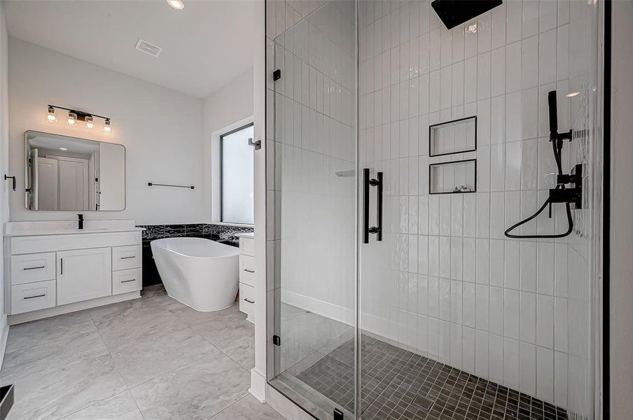 This modern bathroom features a spacious glass-enclosed shower, a freestanding bathtub, and a sleek vanity with ample storage. The neutral tiles and contemporary fixtures create a clean and elegant look.