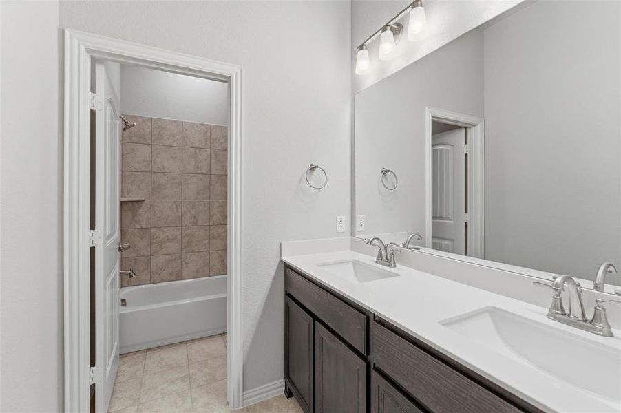 Full bath with double vanity and shower / bathtub combination