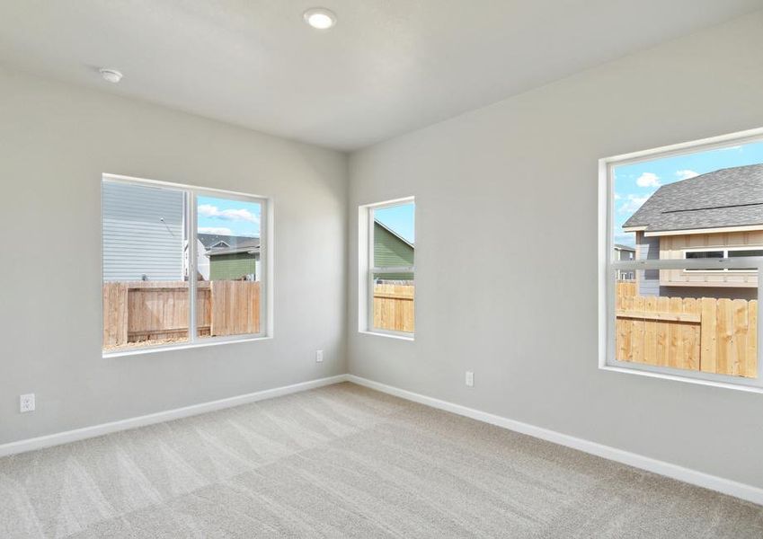 The master bedroom is spacious with windows.