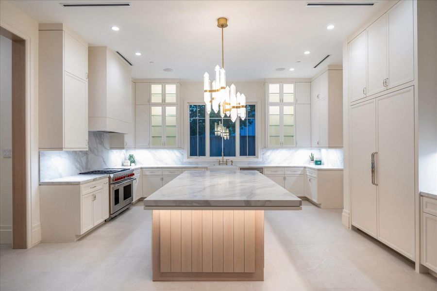 A sophisticated culinary space designed for both style and function, featuring sleek white cabinetry, quartz countertops, and a grand 5’x10’ island. Outfitted with a premium Sub-Zero/Wolf appliance package and illuminated by a modern chandelier, this bright and inviting kitchen is perfect for cooking, gathering, and entertaining.