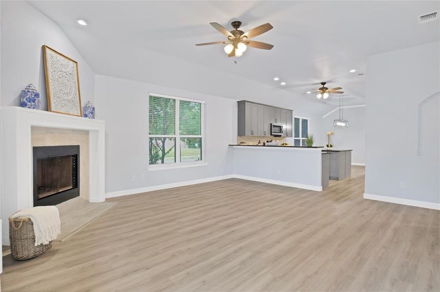 Living room with high ceilings that is open to the kitchen and dining area.