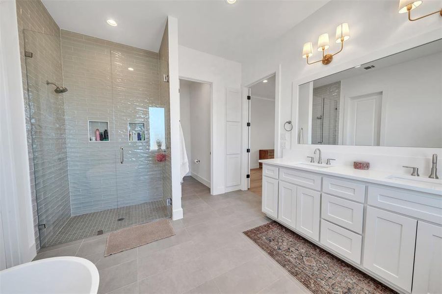 Primary Bathroom with shower with separate bathtub, tile patterned floors, and vanity