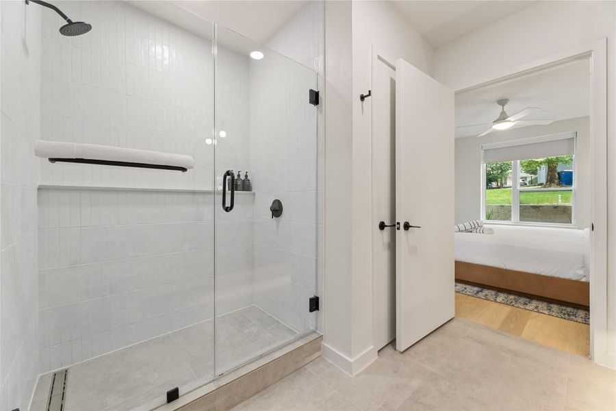Clean tile flooring and a glass-enclosed walk-in shower define this modern bathroom space.