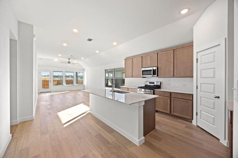 A pristine open-concept kitchen and living area, complete with a generous island and sleek appliances.