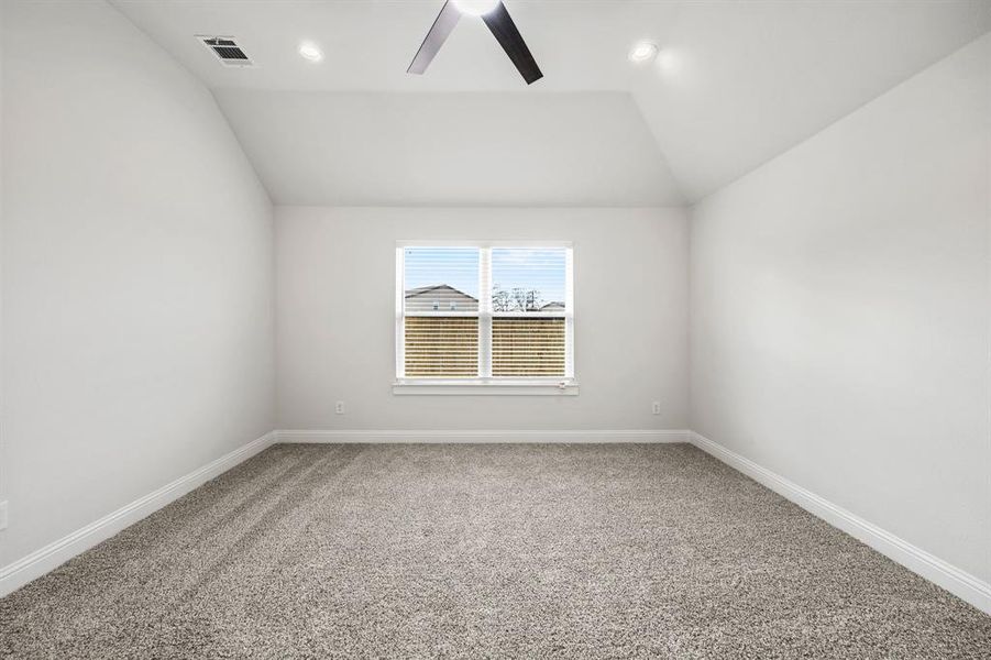 Spare room featuring light colored carpet, vaulted ceiling, ceiling fan, and recessed lighting