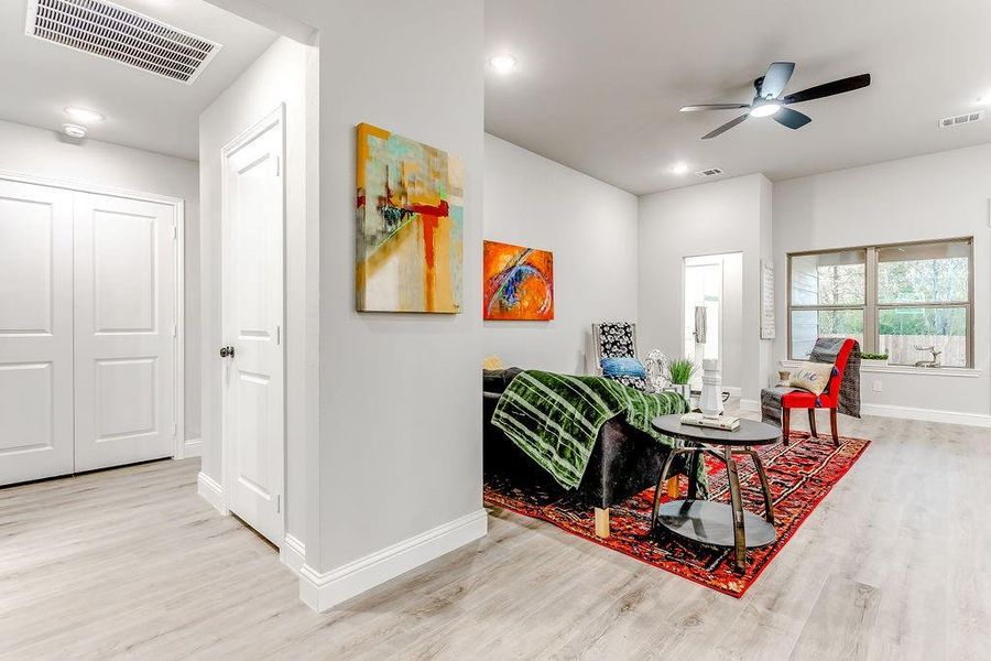 Living room with light hardwood / wood-style floors and ceiling fan