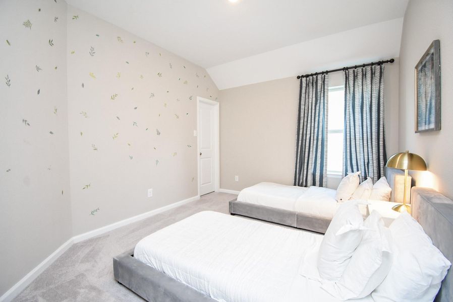 A charming bedroom with soft natural light and stylish wallpaper accents.