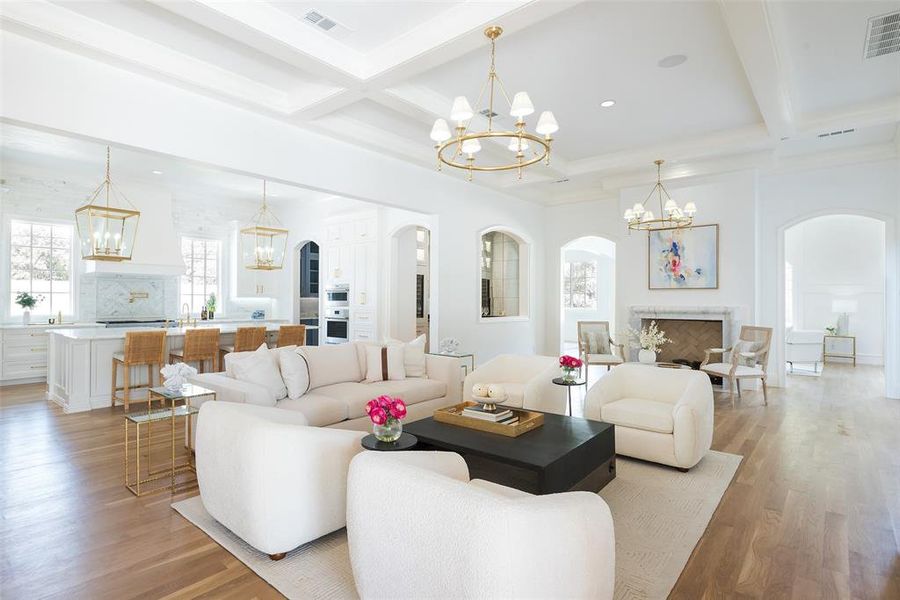 Living room with an inviting chandelier, beamed ceiling, light hardwood / wood floors, and coffered ceiling