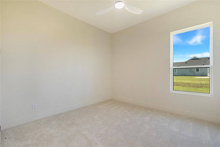 Carpeted empty room with baseboards and ceiling fan Carpeted empty room with baseboards and ceiling fan