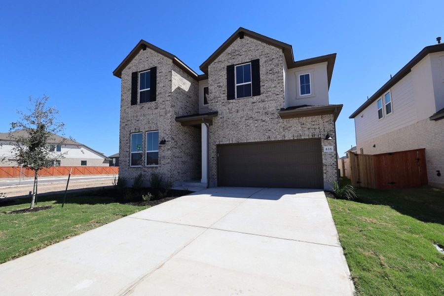 Front exterior of a new home in Lariat, Liberty Hill, TX, highlighting curb appeal (Image 16).