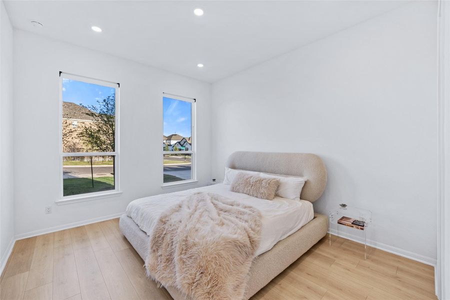 Bedroom with light wood-type flooring and recessed lighting