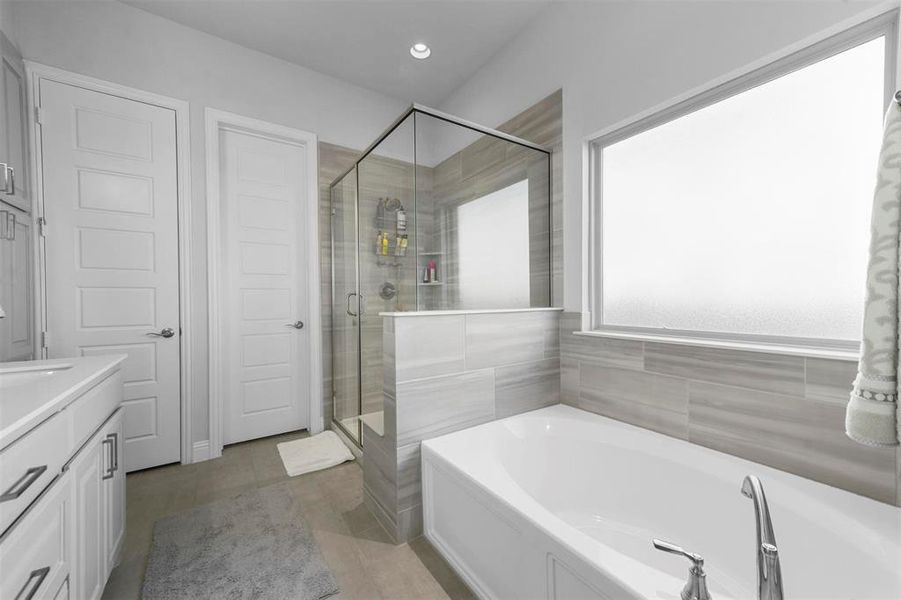 Bathroom with vanity and shower with separate bathtub