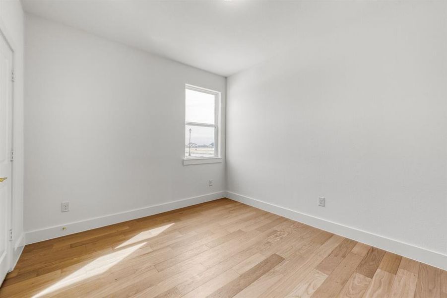 Unfurnished room with baseboards and light wood-type flooring