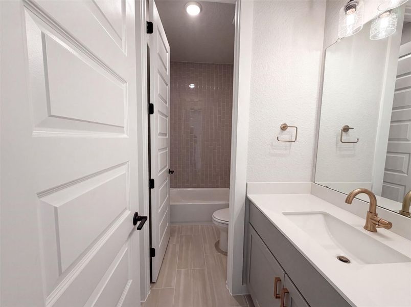 A well-lit bathroom features a modern vanity with a single sink and elegant gold-toned hardware. A well-lit bathroom features a modern vanity with a single sink and elegant gold-toned hardware.