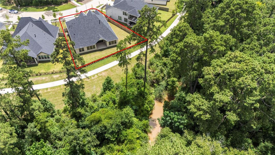 A winding creek flows through the trees, offering privacy and natural beauty.