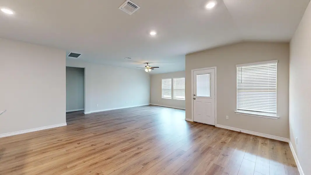 Spare room with light wood-type flooring, a ceiling fan, vaulted ceiling, and recessed lighting