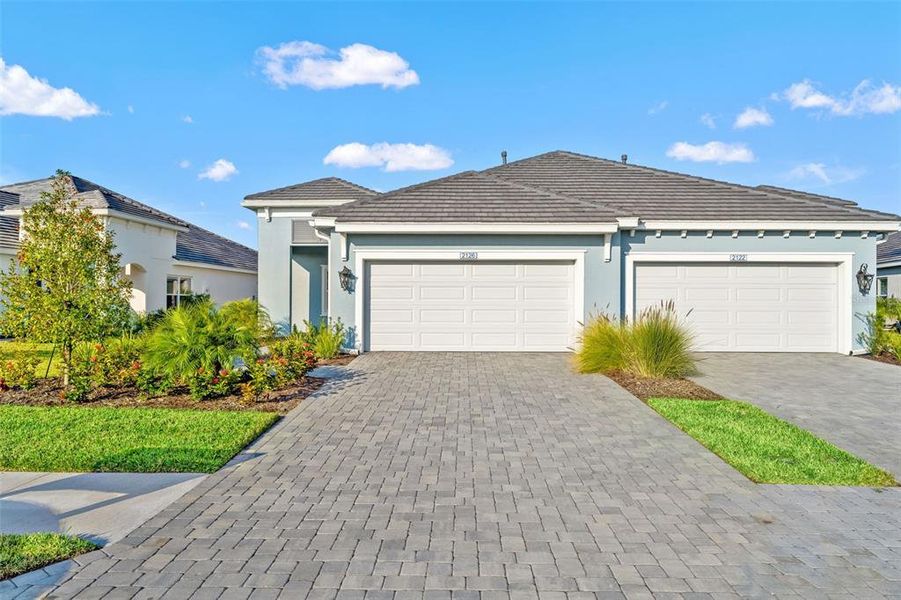 Front exterior of a new home in Palm Grove, Lakewood Ranch, FL, highlighting curb appeal (Image 25). Front exterior of a new home in Palm Grove, Lakewood Ranch, FL, highlighting curb appeal (Image 25).