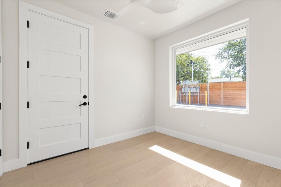 Natural light streams across clean-lined wood flooring in this versatile modern space.