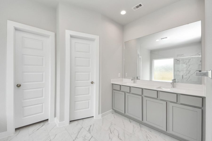Elevate your daily routine at the elegant vanity, now equipped with double sinks, light countertops, modern hardware, and beautiful vanity lights. Sample photo of completed home with similar floor plan. Actual colors and selections may vary. Elevate your daily routine at the elegant vanity, now equipped with double sinks, light countertops, modern hardware, and beautiful vanity lights. Sample photo of completed home with similar floor plan. Actual colors and selections may vary.