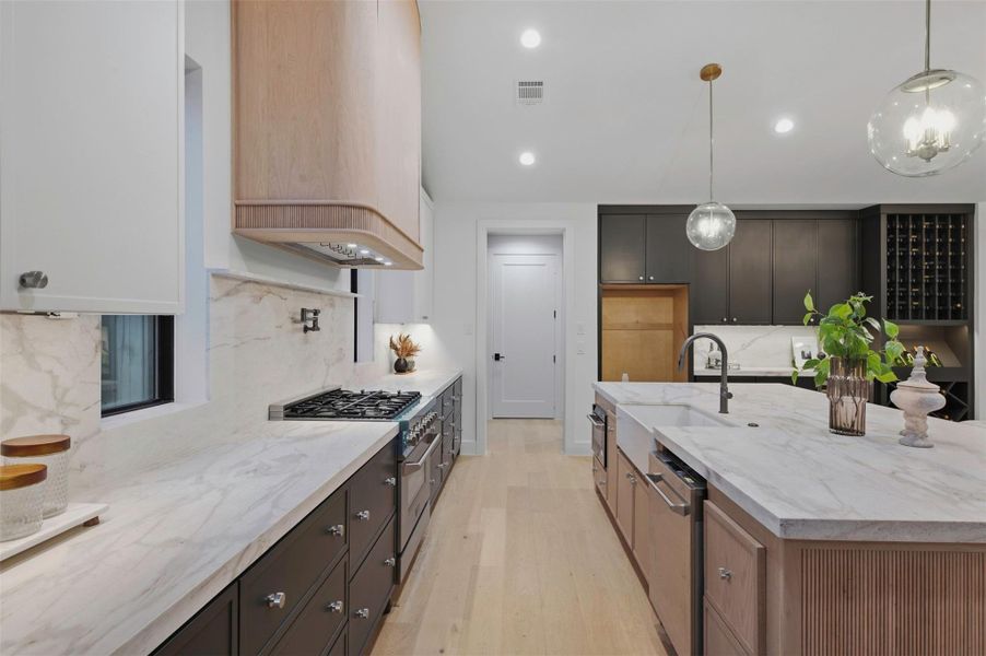 Custom white oak vent hood creates a striking focal point above the range.