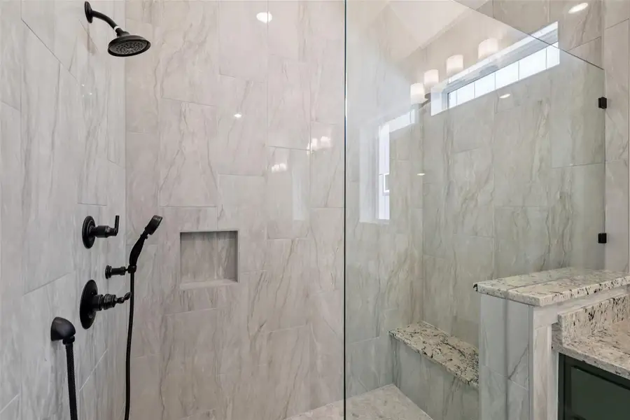 Full bath featuring tiled shower, plenty of natural light, and vanity
