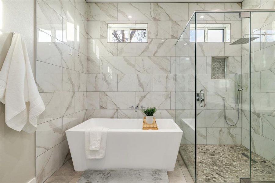 Bathroom featuring tile walls and plus walk in shower