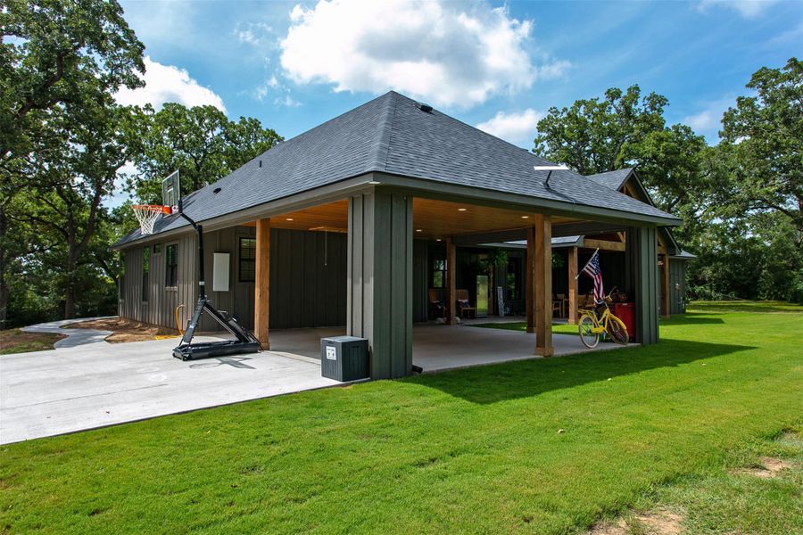 Rear view of property with a patio, a shingled roof, and a yard