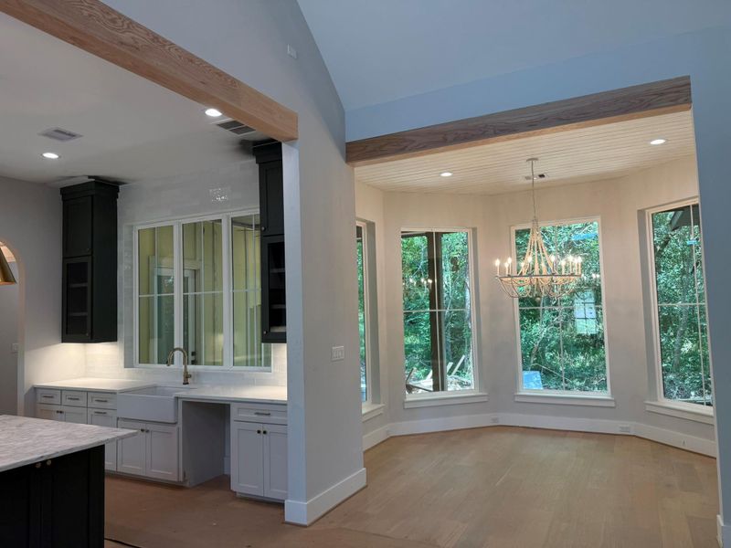 Kitchen with light wood-style floors, a chandelier, recessed lighting, pendant lighting, and light stone counters