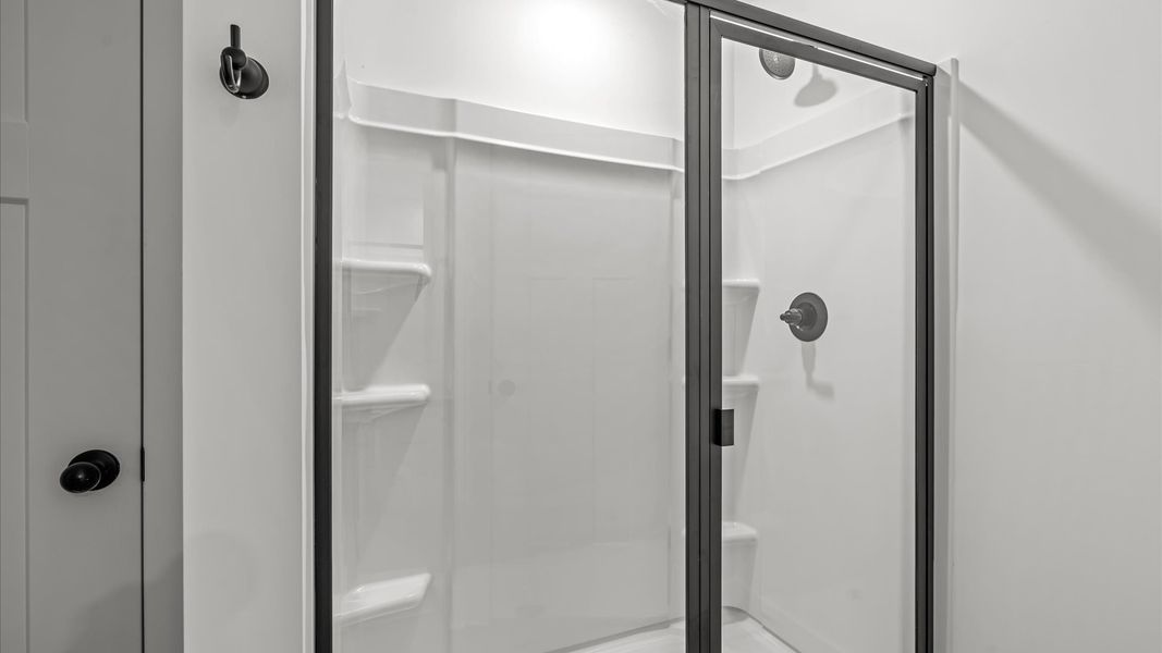 Accomplished design shines in this primary bath with dual vanity and a sleek walk-in shower