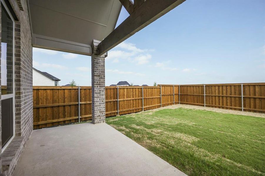 Fenced backyard with a patio