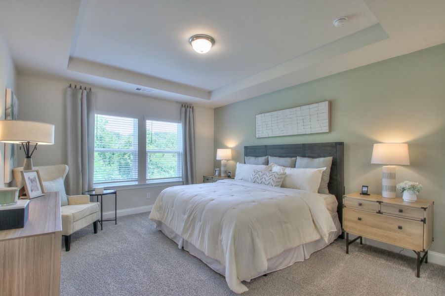 Tray ceilings lend an elegant touch in the luxurious primary suite.