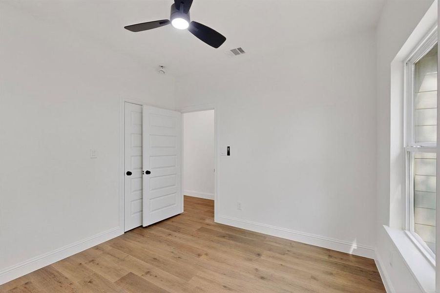 Empty room featuring light wood finished floors and a ceiling fan Empty room featuring light wood finished floors and a ceiling fan