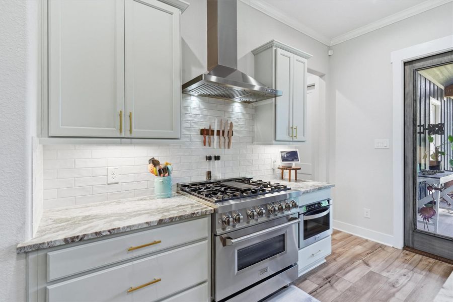 Stainless steel vent hood, gas range and microwave drawer. Shaker style cabinetry, useful set of drawers, brushed brass hardware and under cabinet lighting illuminates workspace. Stainless steel vent hood, gas range and microwave drawer. Shaker style cabinetry, useful set of drawers, brushed brass hardware and under cabinet lighting illuminates workspace.