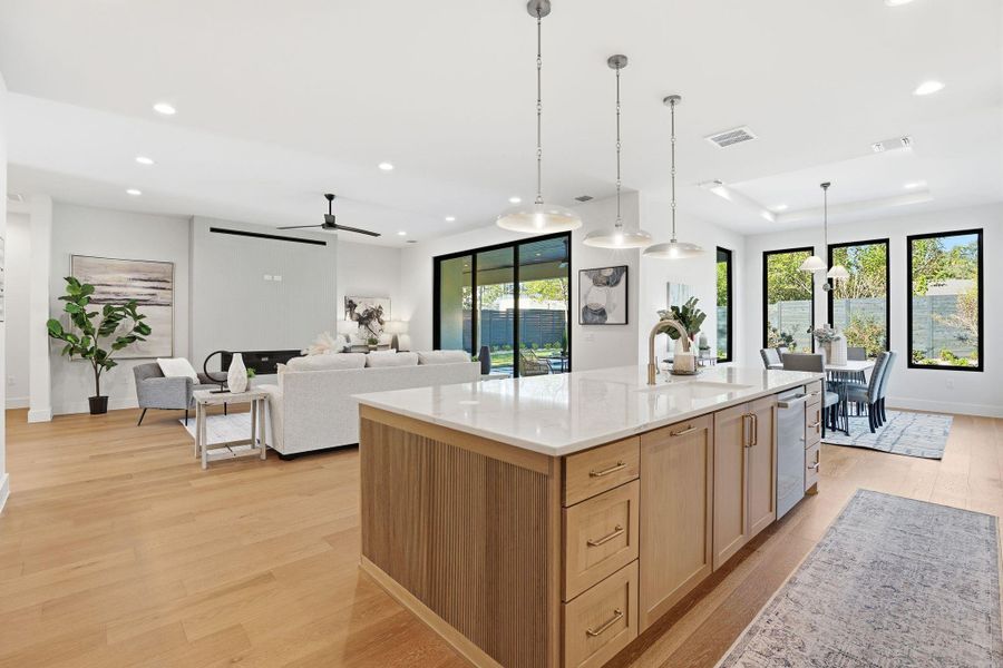 Kitchen featuring light wood finished floors, light stone countertops, light brown cabinets, decorative light fixtures, and recessed lighting Kitchen featuring light wood finished floors, light stone countertops, light brown cabinets, decorative light fixtures, and recessed lighting