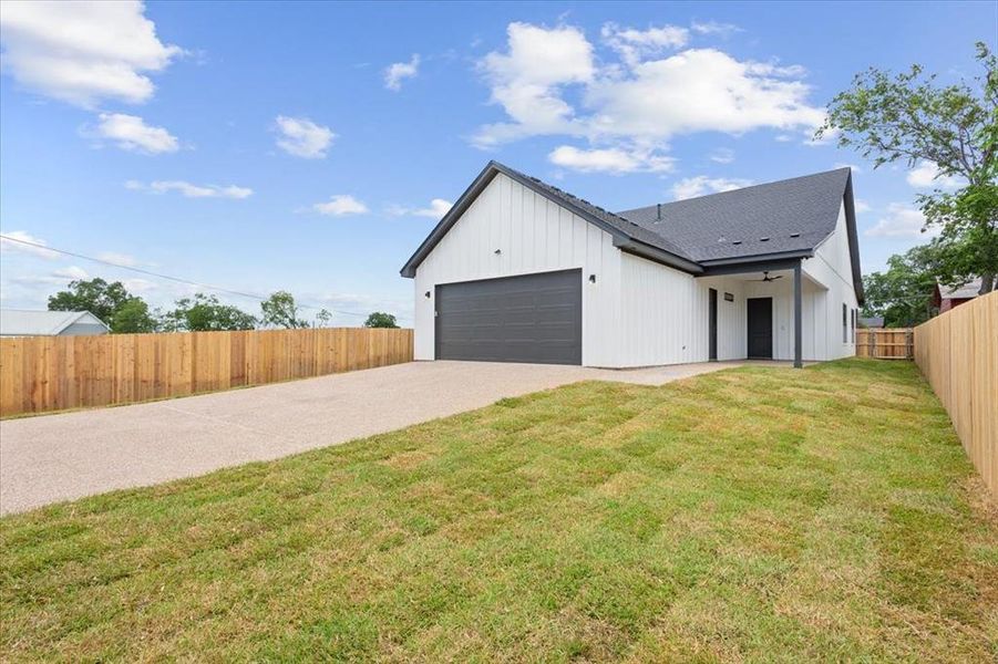 View of back of property with concrete driveway, & a garage View of back of property with concrete driveway, & a garage